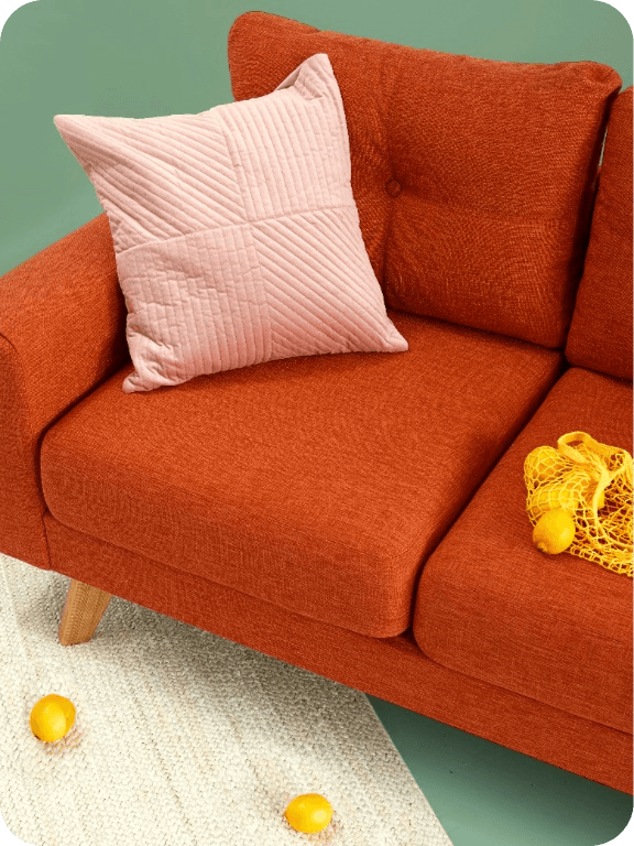 Orange sofa with a pink cushion